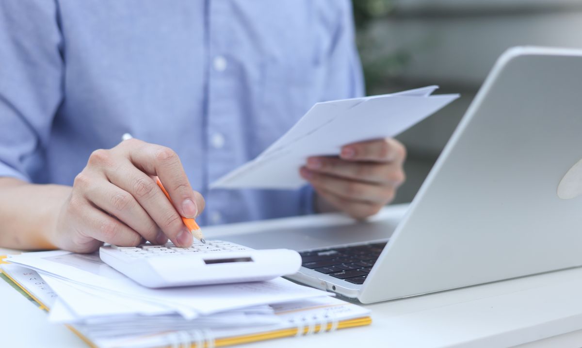 close up man hand press on calculator and check invoice letter from bank to check about debt