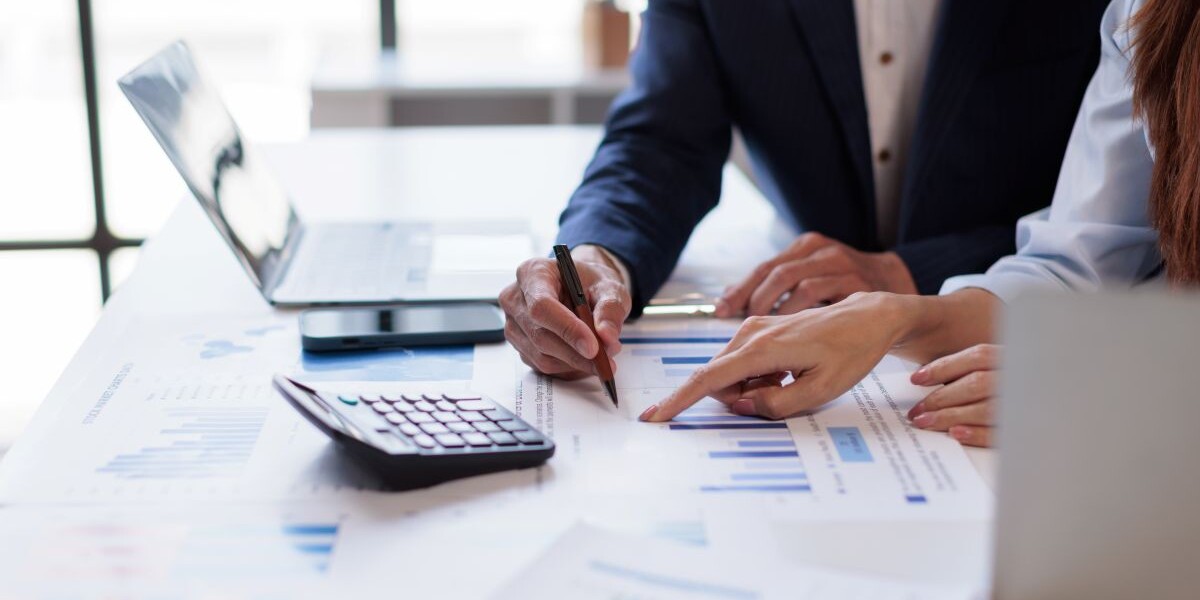 Hands and graphs on tablet screen for finance results, profit growth and budget review.
