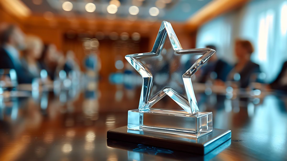 Crystal star award on a wooden table in a conference room setting